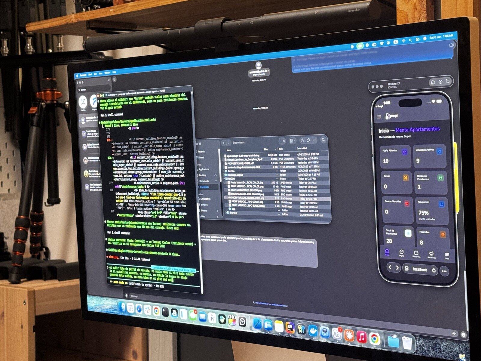Un monitor grande con una sesión de Claude Code a la izquierda y, a la derecha, un simulador de teléfono mostrando la app en modo oscuro: un panel de administración de edificios con tarjetas de métricas.